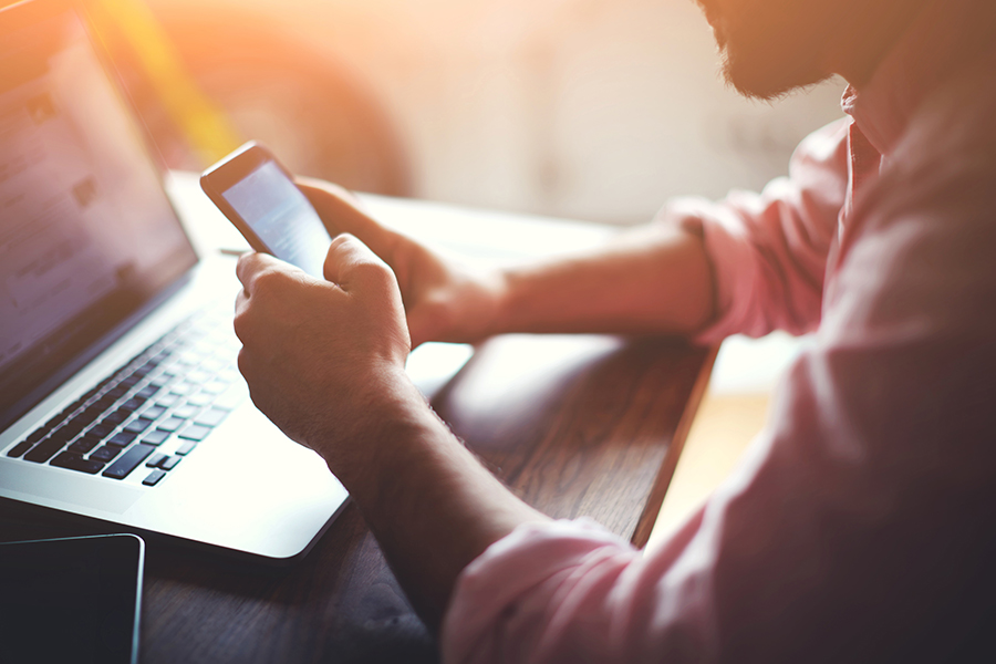 Person using laptop and phone